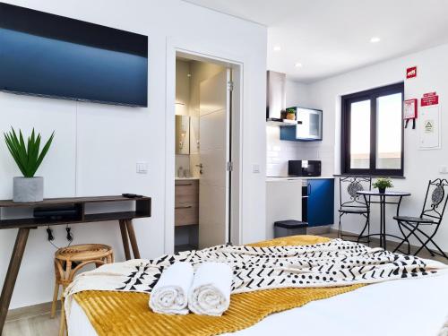 een slaapkamer met een bed en een bureau in een kamer bij CASINHA DE FERRAGUDO - Terraço Privado, AC, WiFi, Centro 250m in Ferragudo