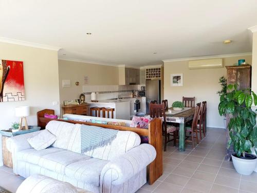 een woonkamer met een bank en een eetkamer bij Scenic Villa -Second Storey in Lake Hume