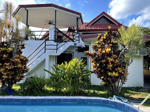 a house with a swimming pool in front of it at Charming 3-Bedroom Country Farm Home Pool ParkSprings Lipa in Lipa