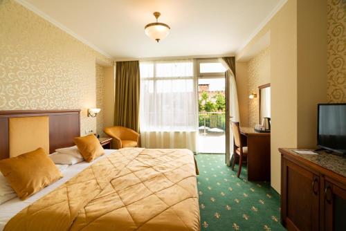 une chambre d'hôtel avec un lit et une télévision dans l'établissement Elizabeth Hotel, à Gyula