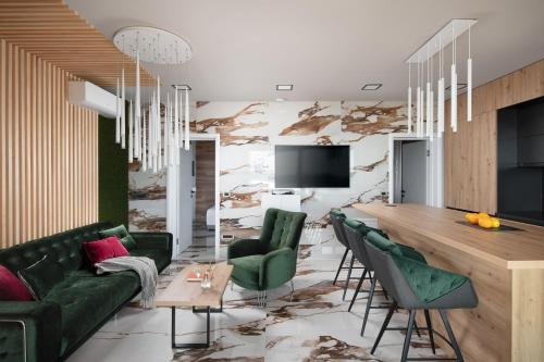 a living room with a table and green chairs at Villa SPA DECK 1, DECK 2, DECK 3 in Dramalj