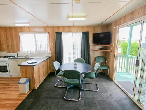 a kitchen with a table and chairs in a room at BIG4 Ulverstone Holiday Park in Ulverstone