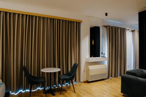 a living room with a couch and a table and chairs at Sharm Hotel Luxury in Gjirokastër
