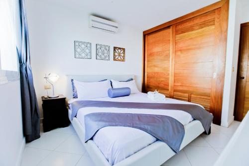 sypialnia z dużym łóżkiem z drewnianymi drzwiami w obiekcie Best Family Vacation Apartment for Rent on the Beach w Punta Cana