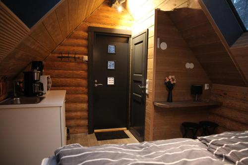Cette chambre comprend un lit, un lavabo et une porte. dans l'établissement Rafi - The Village of Silence, à Tepsa
