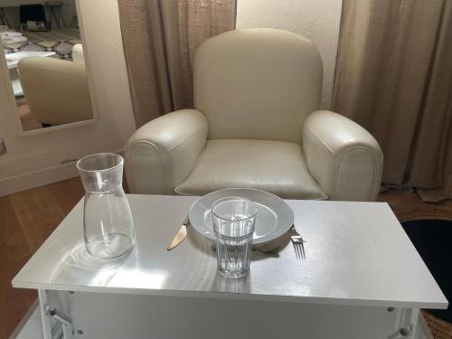 una mesa blanca con una silla, un plato y un vaso en Ty Logis en Montrabé
