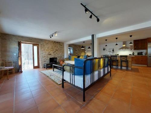 un soggiorno con divano blu e una cucina di Casa Férias Retiro do Rodeiras a Figueira de Castelo Rodrigo