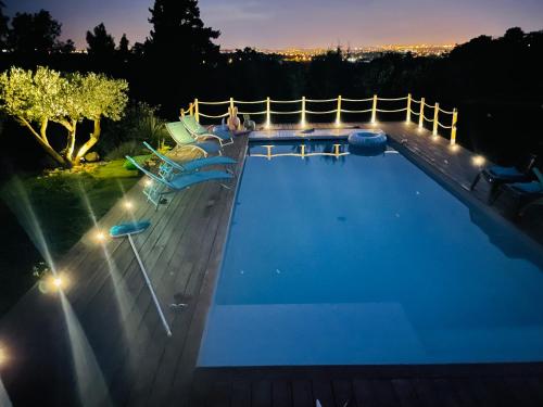 una piscina por la noche con luces en la terraza en Ty Logis en Montrabé