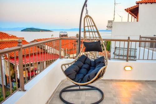 a swing on a balcony with a view of the ocean at La Maison Plakes Rooftop Apt in Skiathos