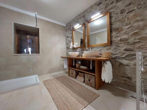 baño con 2 lavabos y pared de piedra en Casa Férias Retiro do Rodeiras, en Figueira de Castelo Rodrigo