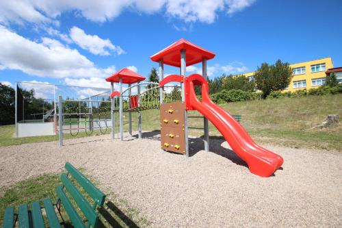 a playground with a red slide in a park at Panorama Ferien Hotel Harz in Güntersberge