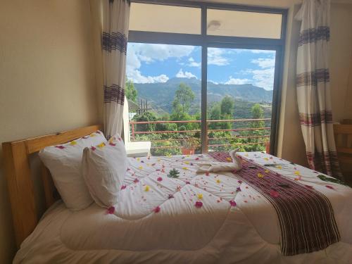a bedroom with a bed and a large window at Sora Lodge Lalibela in Lalībela