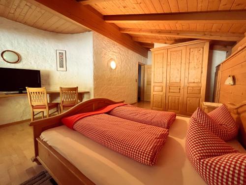 a bedroom with a bed with red and white pillows at Schulhaus Tirol in Zell am Ziller