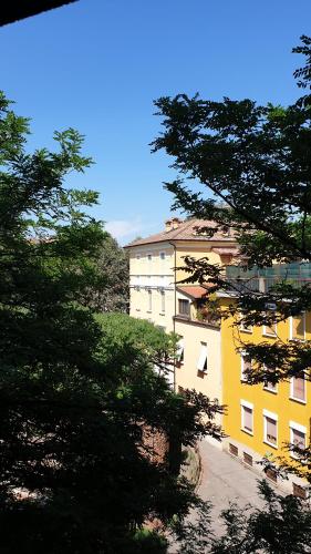 żółty budynek z drzewami przed nim w obiekcie bb26 Piave apartment city center w mieście Cremona