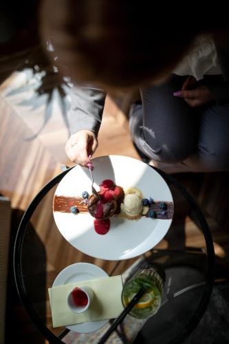 a person eating food on a plate on a table at Jump INN Hotel Belgrade in Belgrade