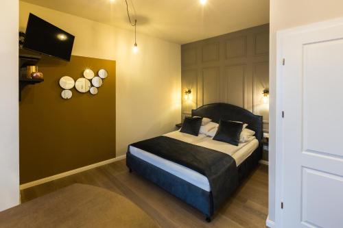 a bedroom with a bed and a wall with plates on it at Apáca 30 Apartman **** Győr in Győr