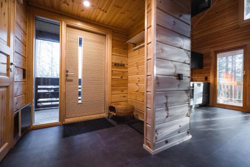 a room with wooden walls and a large window at Black Work Levi Aihki in Kittilä