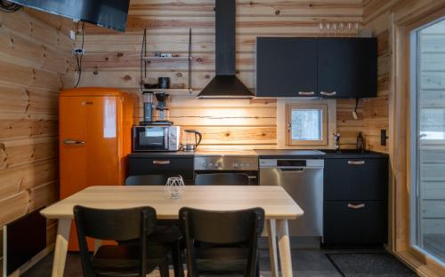 a kitchen with wooden walls and a table and chairs at Black Work Levi Aihki in Kittilä