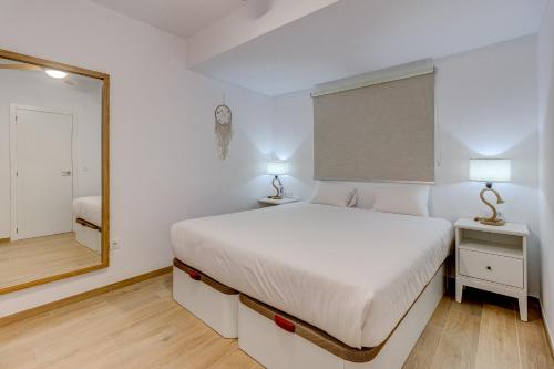 a bedroom with a white bed and a mirror at Sea sand and sun in Callao Salvaje