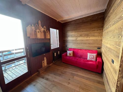 a living room with a red couch and a window at Panorama Chalet a La Grand'Ourse di Cervinia CIR VDA Valtournenche 0198 in Breuil-Cervinia