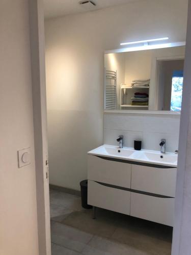 a bathroom with two sinks and a mirror at Villa avec Jacuzzi in Saint-Martin-de-Londres