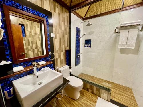 a bathroom with a sink and a toilet and a shower at Shark lounge in Fuvahmulah