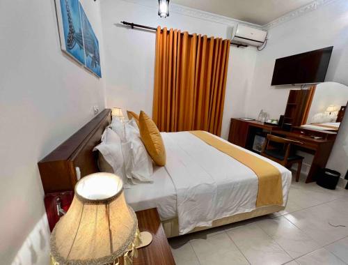a bedroom with a bed and a desk with a computer at Shark lounge in Fuvahmulah