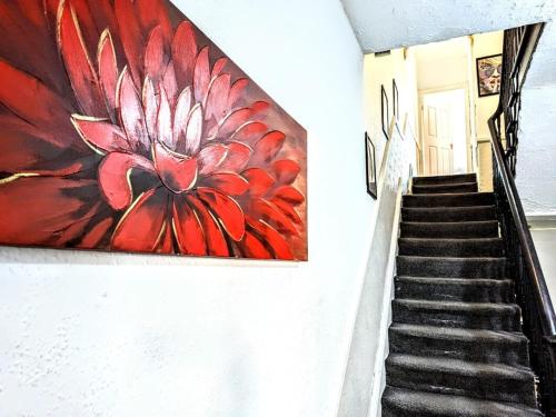a painting of a red flower on a wall at Contractor HQ Spacious & Central 4 Bed Home in Newcastle upon Tyne
