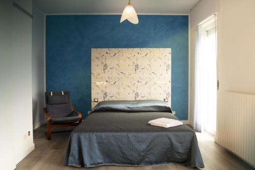 um quarto com uma cama e uma parede azul em Residence La Quiete em Alba