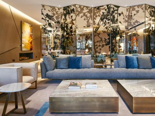 sala de estar con sofá azul y mesa en VP Plaza España Design, en Madrid