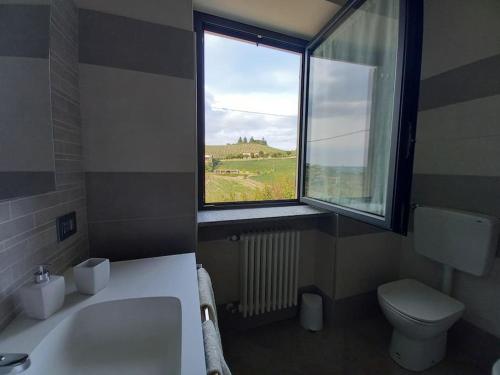 baño con lavabo y aseo y ventana en Casa Pajè en Barbaresco