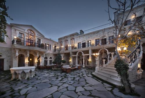 a large mansion with a stone courtyard at night at Sacred House in Urgup