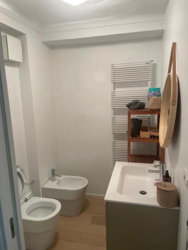 een witte badkamer met een toilet en een wastafel bij Loft Crimea con patio in Turijn