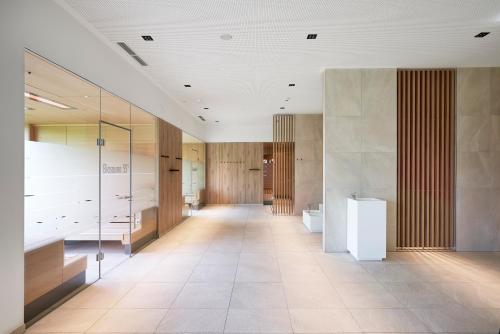 um corredor de um edifício com paredes de madeira e piso de azulejo em Spa Hotel Bründl em Bad Leonfelden