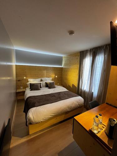 a bedroom with a large bed and a desk at 9WAGRAM Hotel Boutique in Le Mans