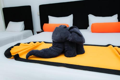 a stuffed animal is sitting on a bed at Celestial Inn in Mirissa