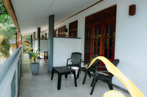 a balcony with chairs and a water hose at Celestial Inn in Mirissa