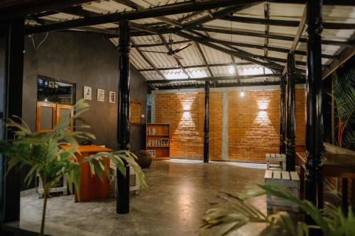 a large room with brick walls and plants in it at Celestial Inn in Mirissa