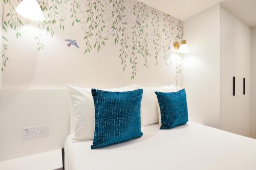 ein Schlafzimmer mit einem Bett mit blauen Kissen in der Unterkunft Sale Place Serviced Apartments by Concept Apartments in London