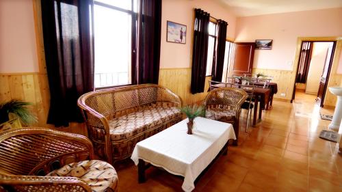 a living room with wicker chairs and a table at Thakur homes- couple and family friendly homestay in Shimla