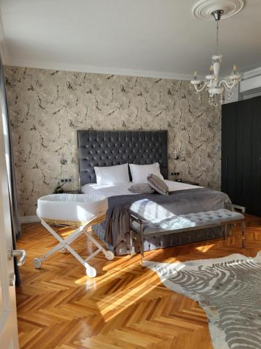 a bedroom with a large bed with a bench at Fancy Flats in Sibiu