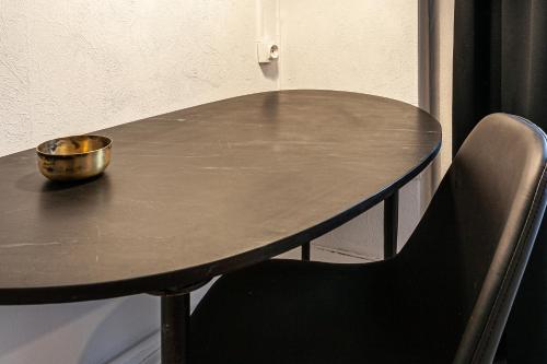 a table with a bowl on it and two chairs at Hôtel du Commerce in Cluny