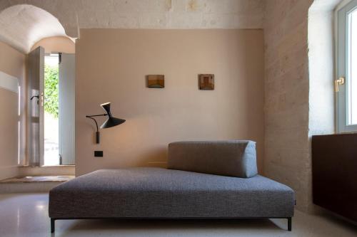 a bedroom with a bed and a lamp on the wall at PIANELLE RESORT in Matera