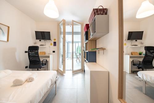 sypialnia z 2 łóżkami i biurkiem z krzesłami w obiekcie Renovated APT with Garden & Veranda! w Mediolanie