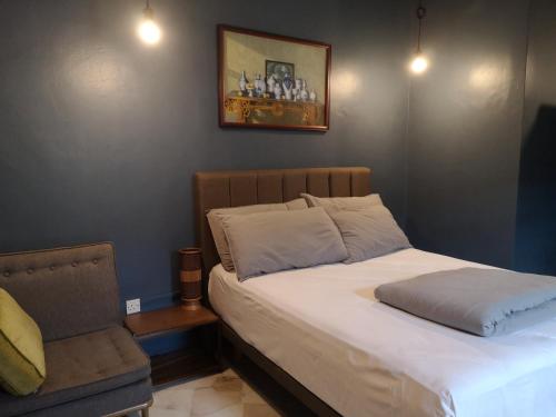 a bedroom with a bed and a chair in it at REQUELstore in Sungai Pelik