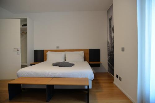 a bedroom with a white bed and a wooden table at La Villa - Luxury Guest House in Trento