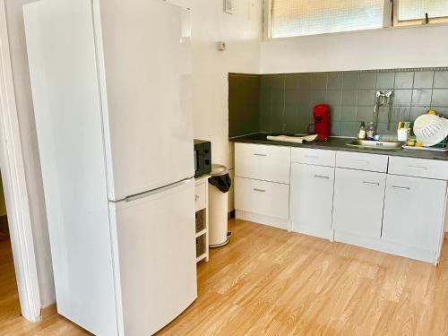  La cuisine est équipée de placards blancs et d'un réfrigérateur. dans l'établissement Le Saint Jaumes parking inclus, à Montpellier