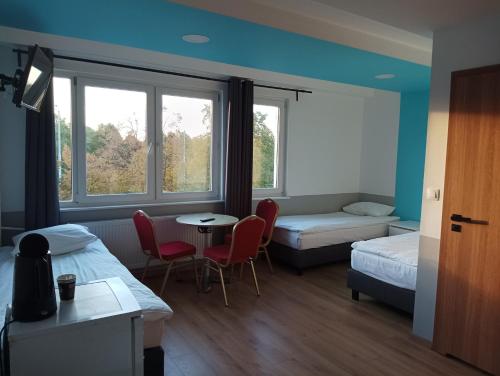 um quarto com duas camas e uma mesa e cadeiras em Ośrodek Pomeranka em Gdansk