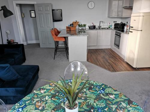 sala de estar con mesa y cocina en Upmarket 2 bedroom apartment with sea views, en Torquay