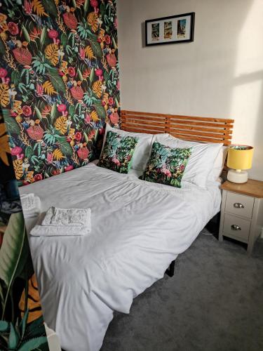 Una cama con sábanas blancas y almohadas en un dormitorio en Upmarket 2 bedroom apartment with sea views, en Torquay